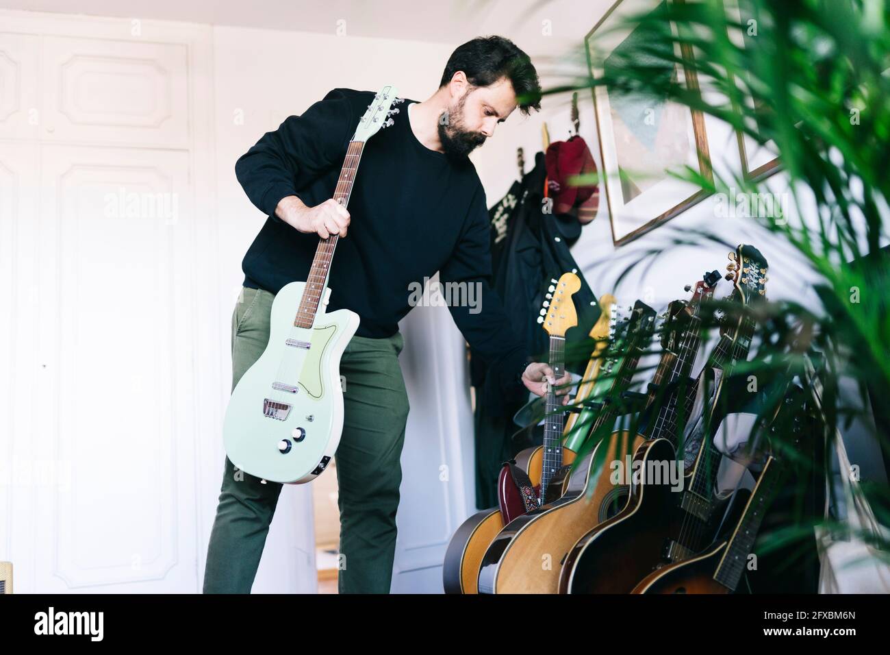 Man selecting guitars in studio Stock Photo