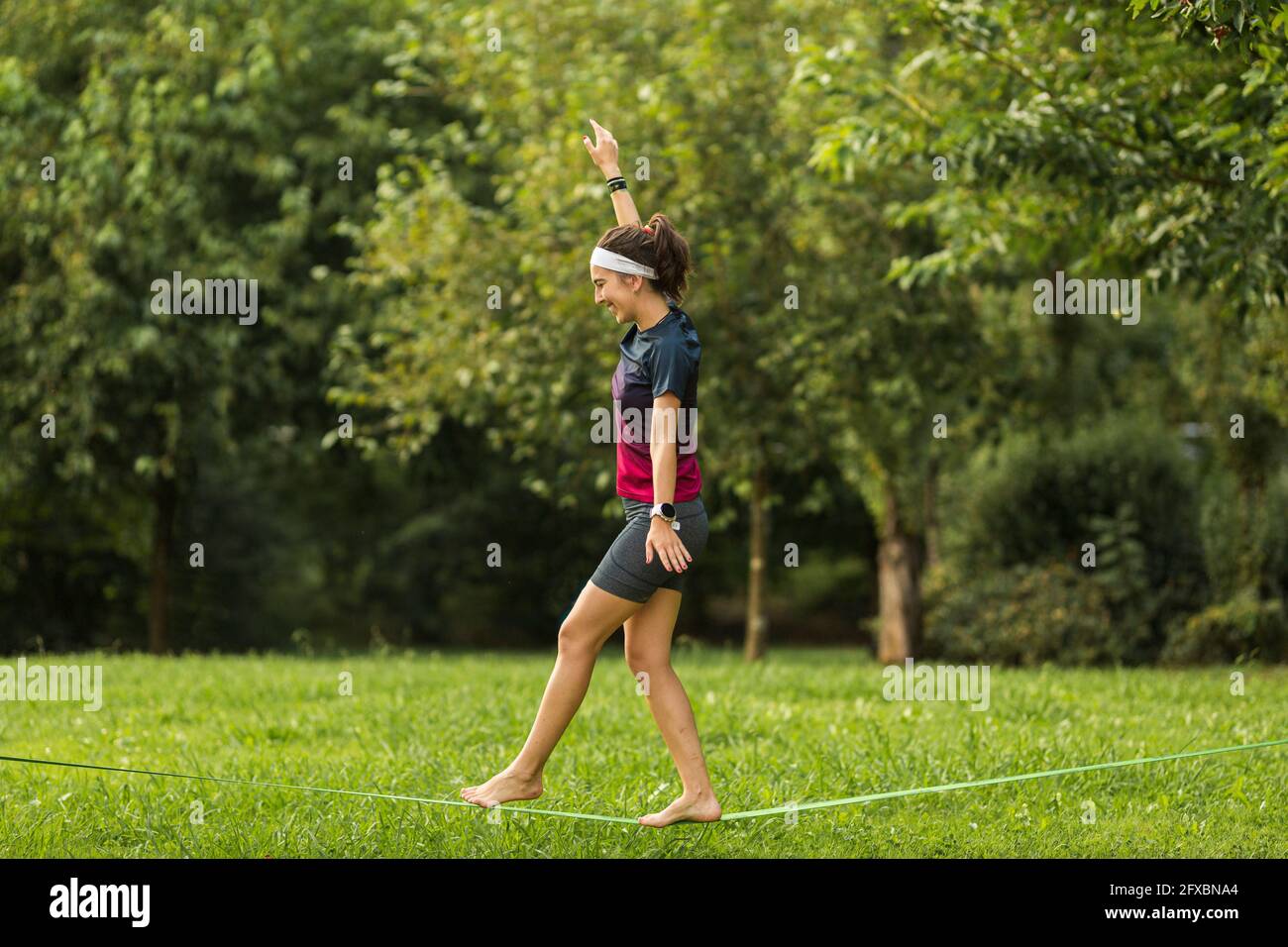 Female sportsperson slacklining at park Stock Photo