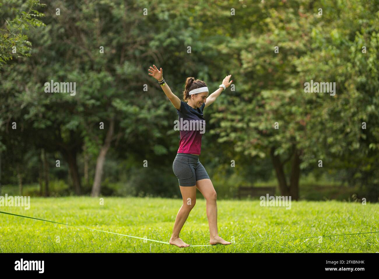 Female athlete slacklining at public park Stock Photo - Alamy