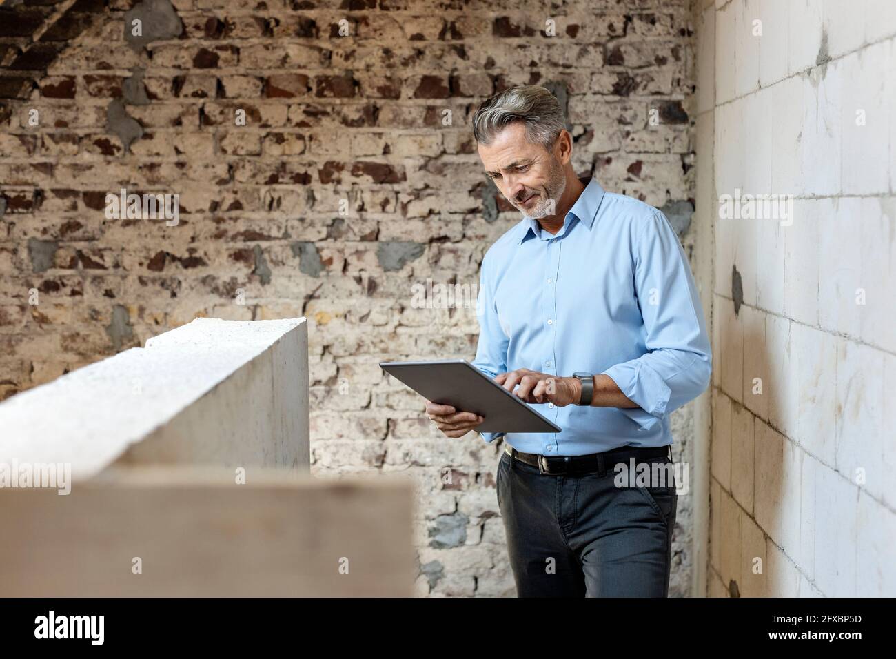 Male architect using digital tablet at construction site Stock Photo