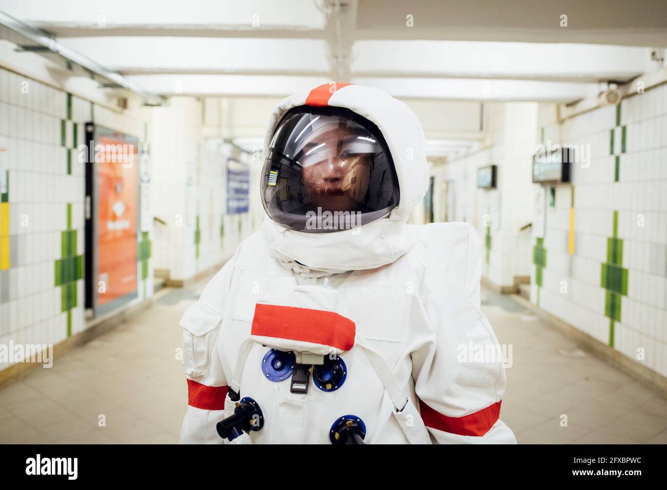Young female astronaut standing in subway Stock Photo