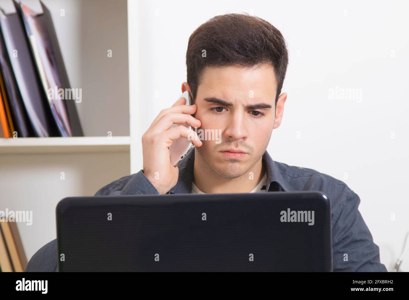 man in the office or home speaking by phone Stock Photo
