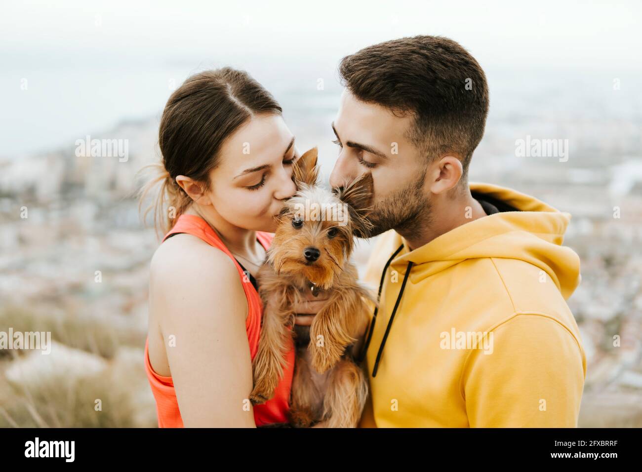 Girlfriend and boyfriend kissing pet together Stock Photo Alamy