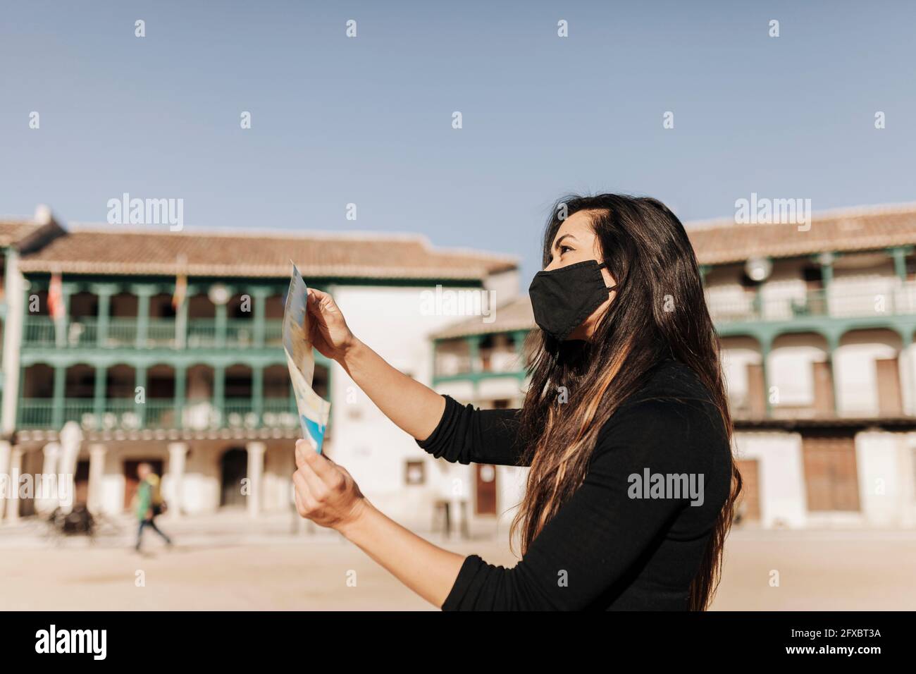 Tourist wearing protective face mask checking map Stock Photo