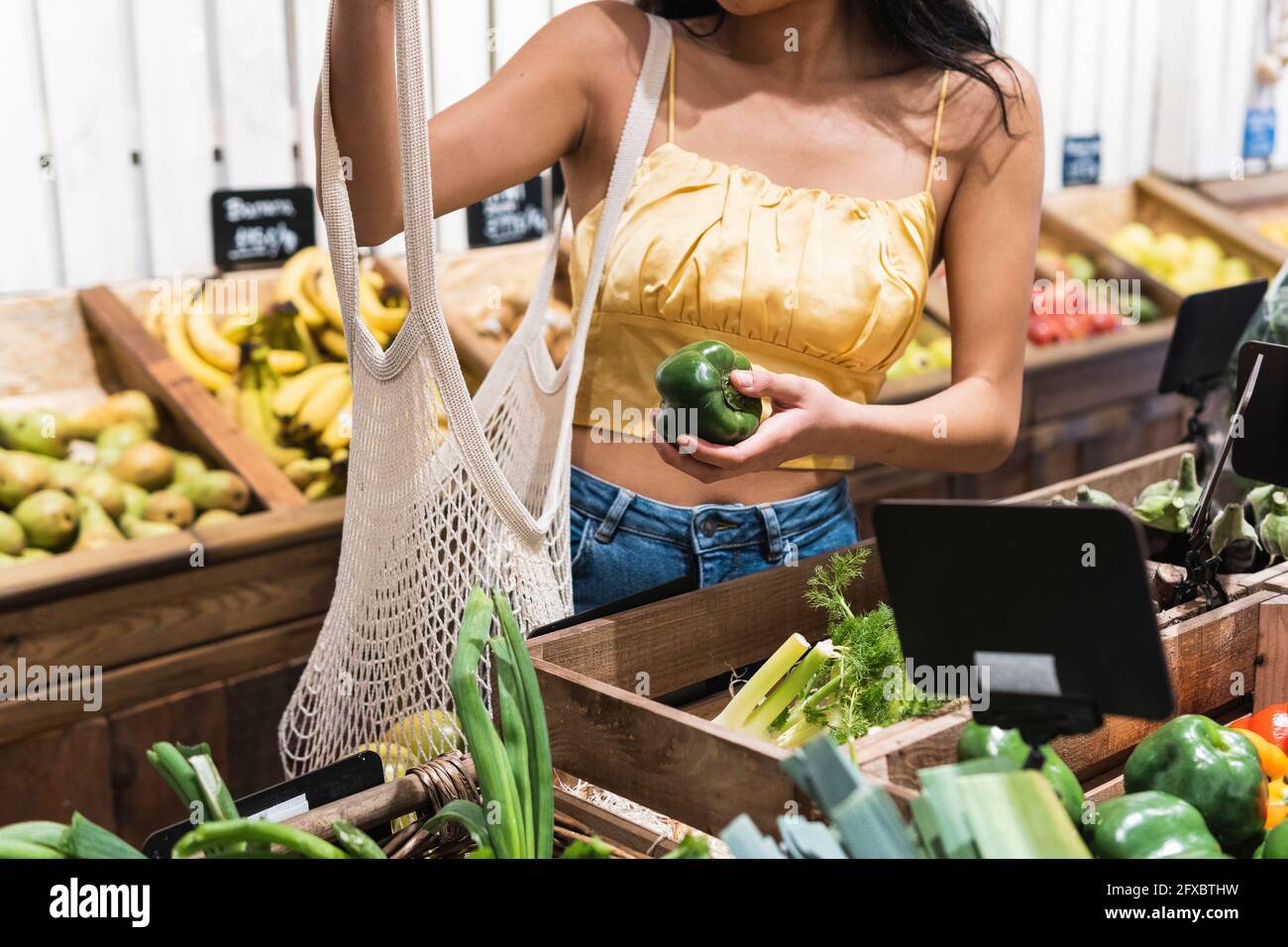 Woman buying green peppers at grocery store Stock Photo Alamy