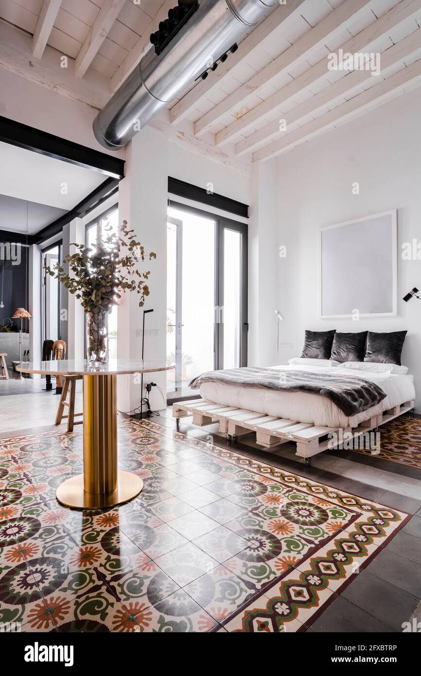 Bed and tiled floor at loft apartment Stock Photo