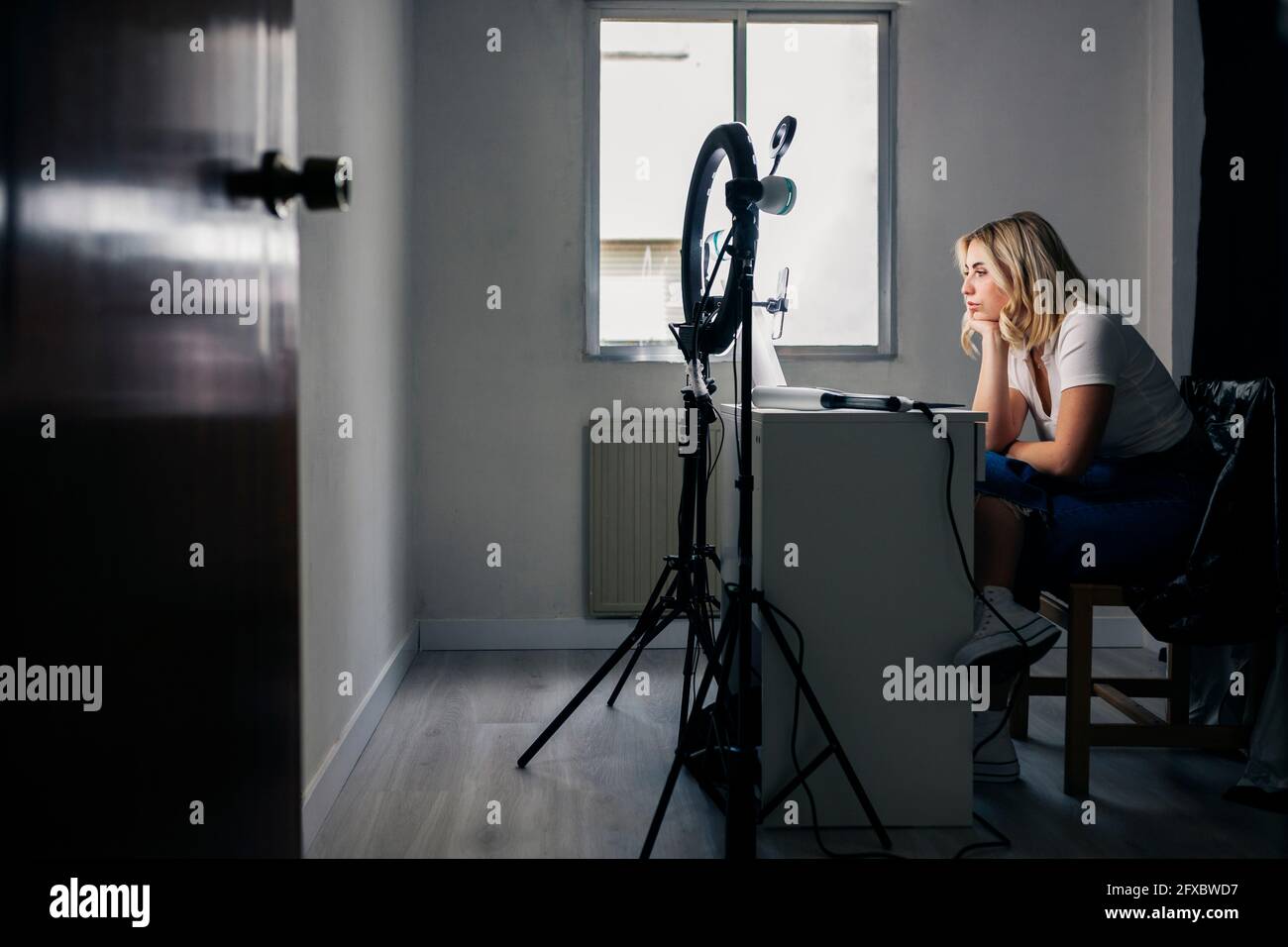 Female fashion model recording through mobile phone at studio Stock Photo