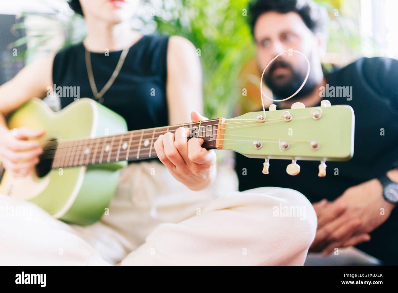 Female musician playing guitar by male composer Stock Photo