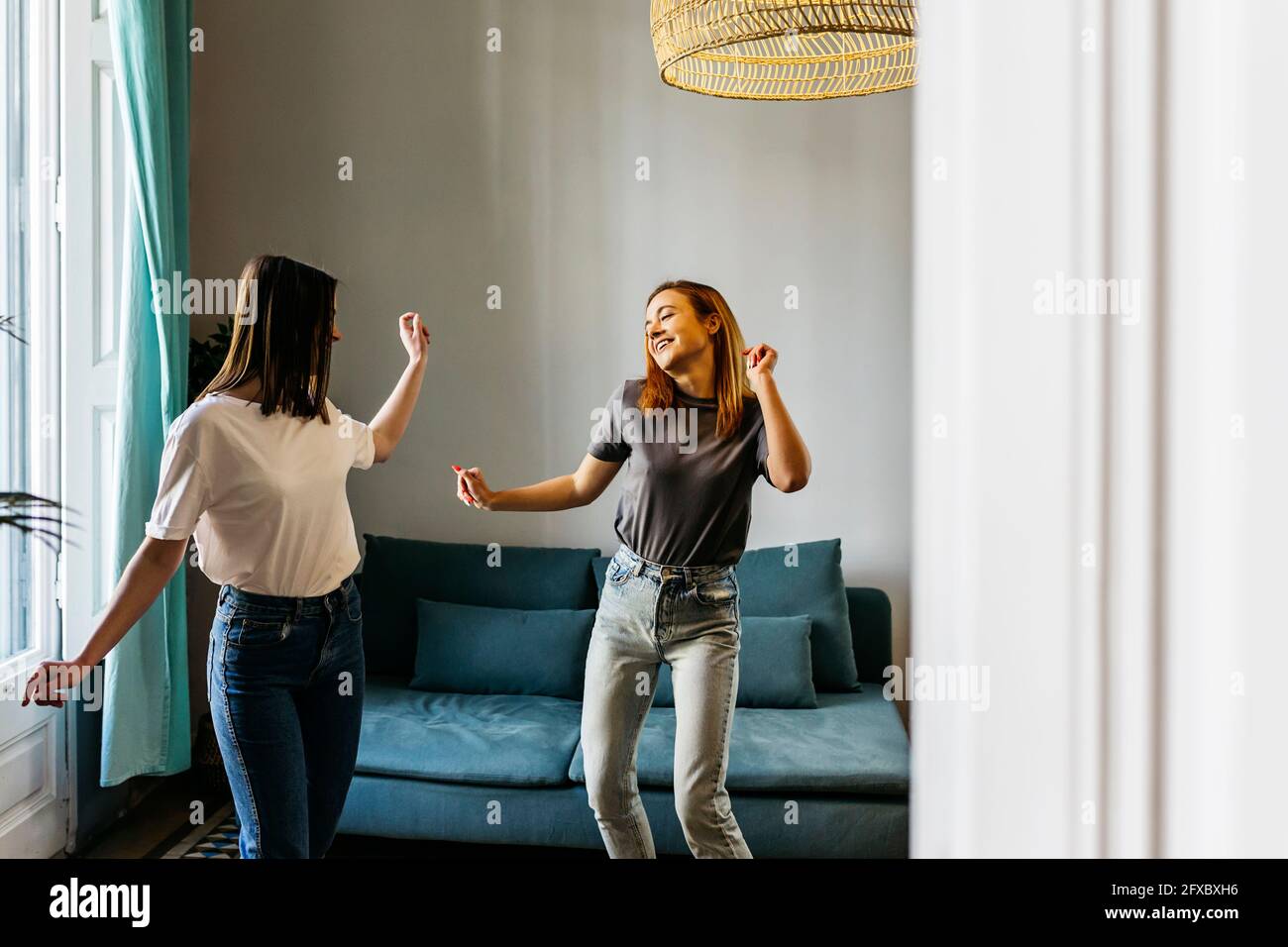 Female friends dancing in living room at home Stock Photo