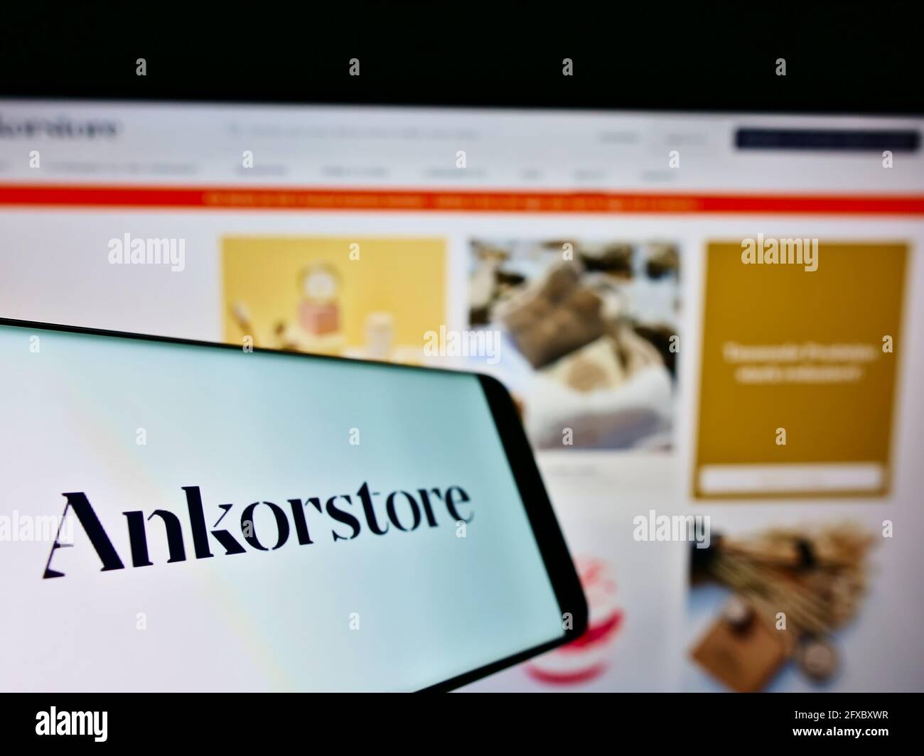 Smartphone with logo of French B2B marketplace company Ankorstore SAS on screen in front of company website. Focus on center-left of phone display. Stock Photo