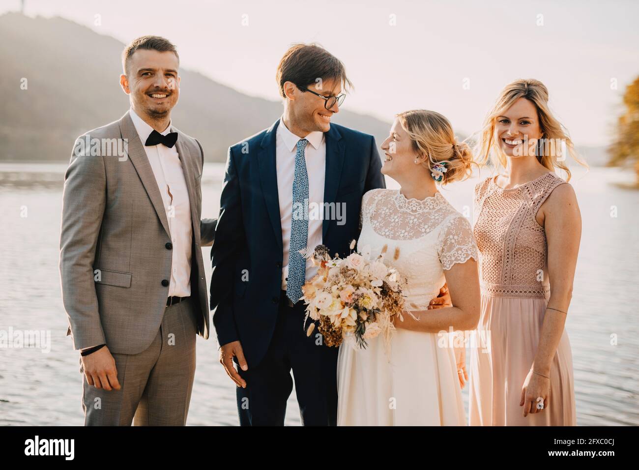 Smiling bride and groom with guests during wedding ceremony Stock Photo ...