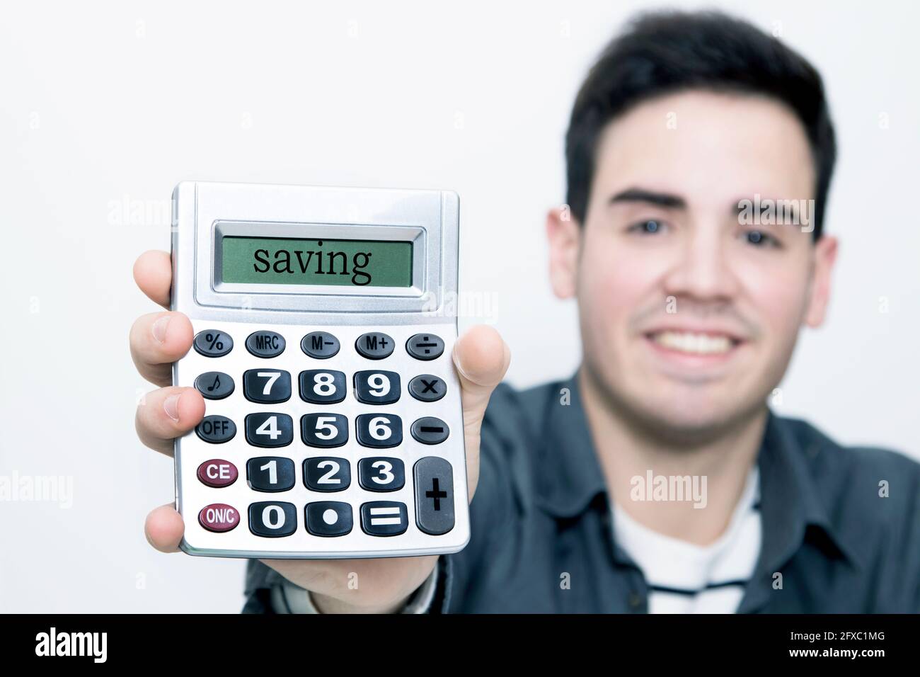 calculator in first plane with man to the background smiling Stock Photo