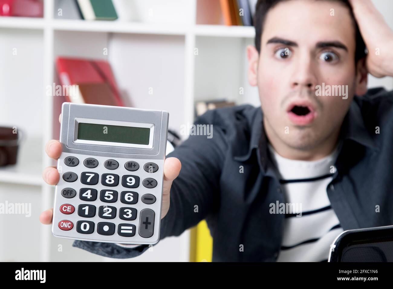 calculator in first plane with man afraid Stock Photo