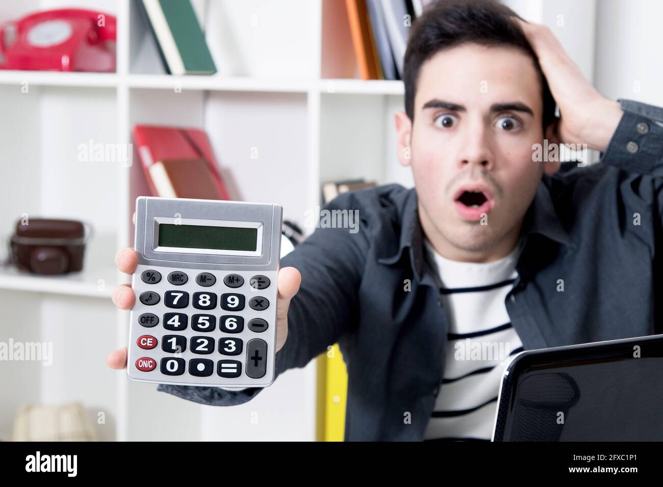 calculator in first plane with man afraid Stock Photo