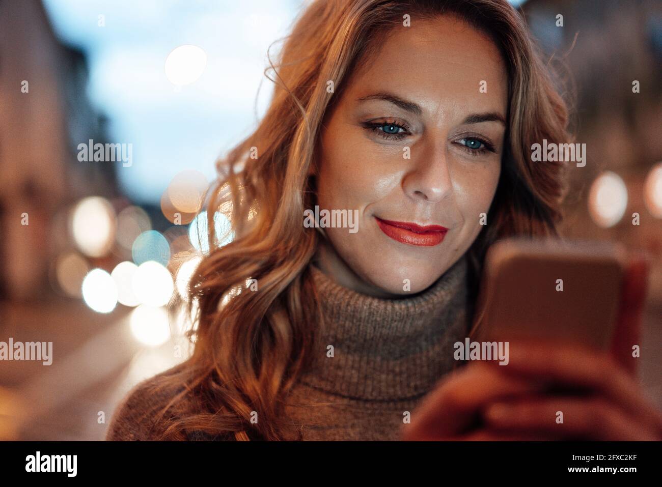 Blond woman using smart phone Stock Photo