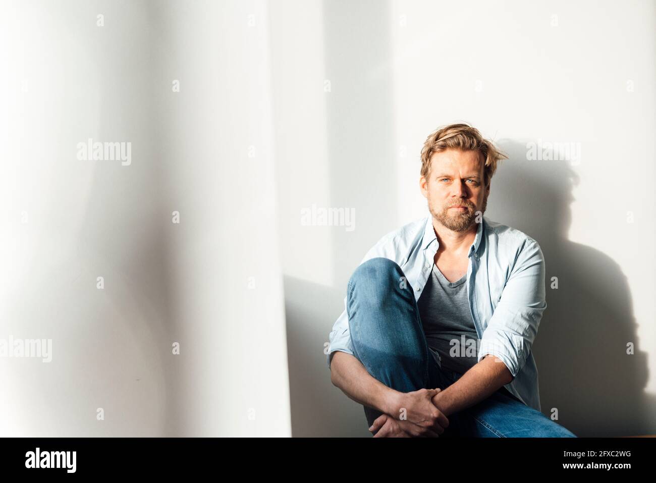 Man sitting hugging knees hi-res stock photography and images - Alamy