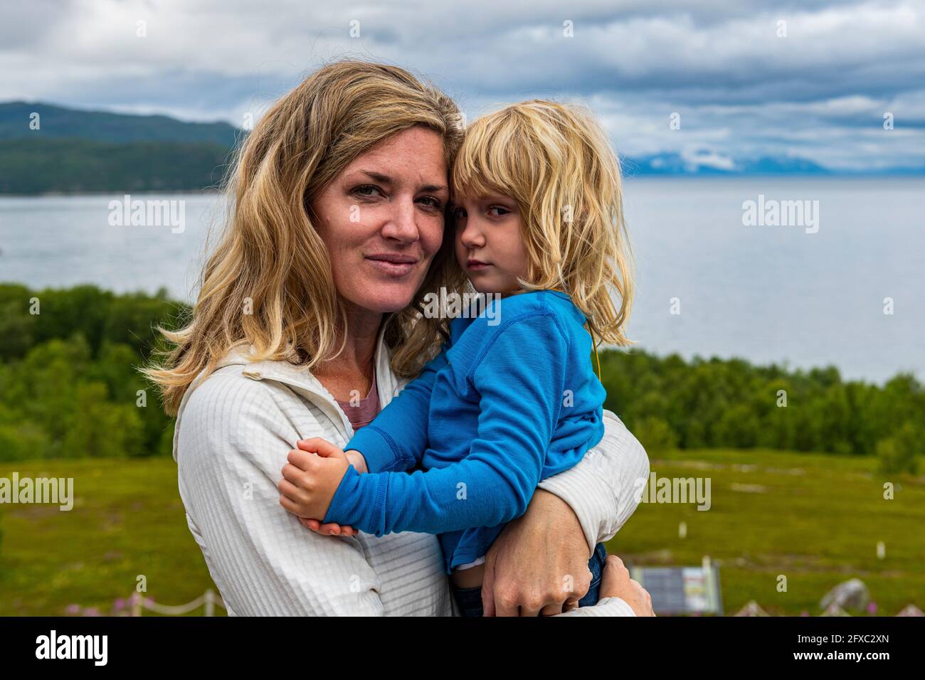 Mother carrying daughter in arms hires stock photography and images