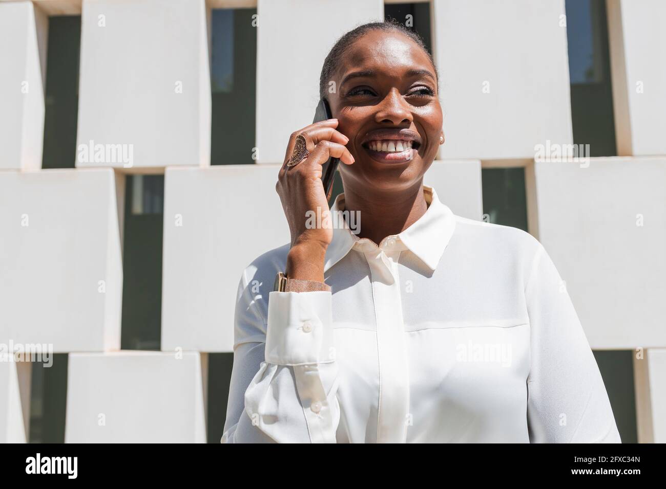 Female business person smiling while talking on mobile phone Stock Photo