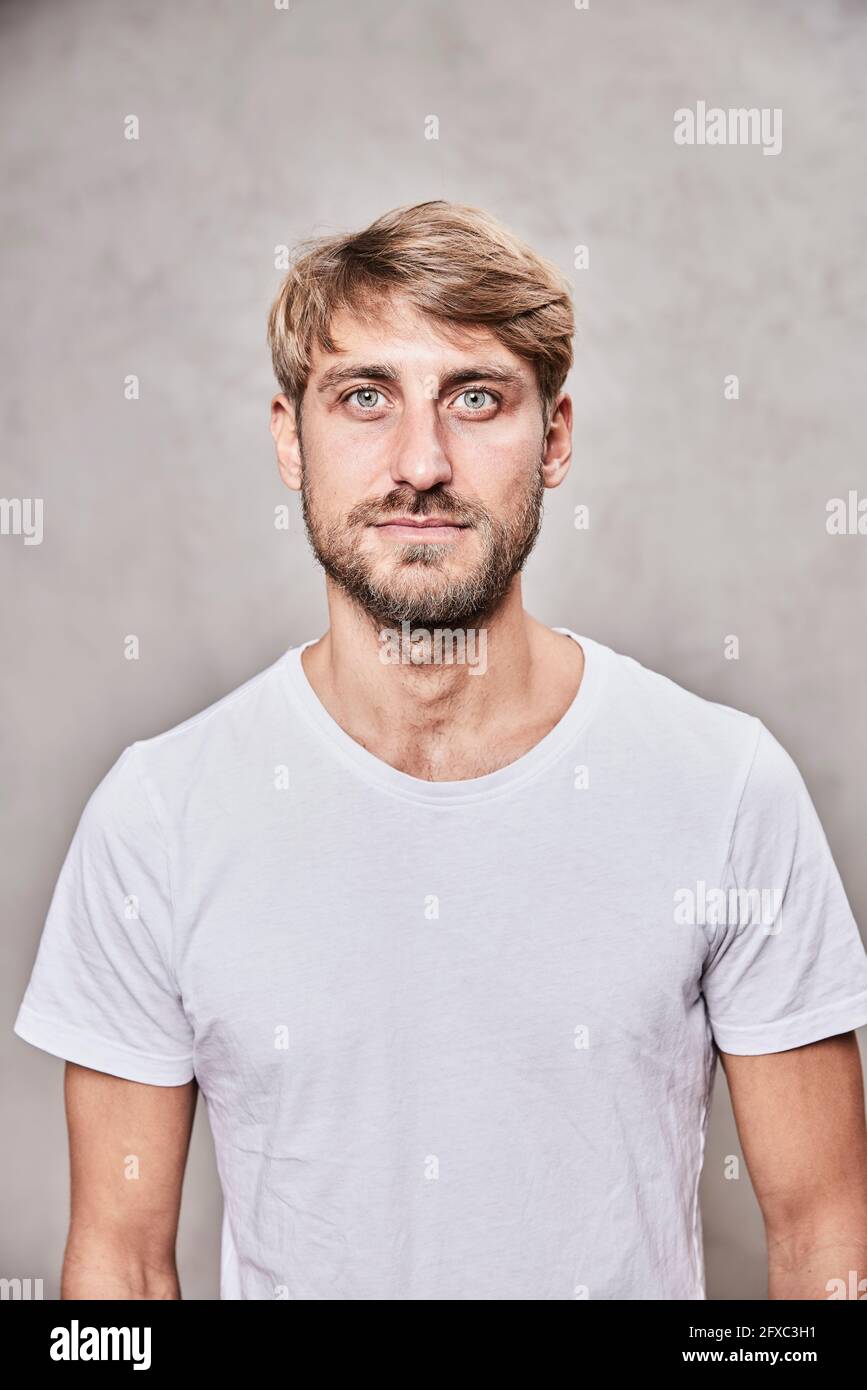 Handsome bearded man staring in front of wall Stock Photo
