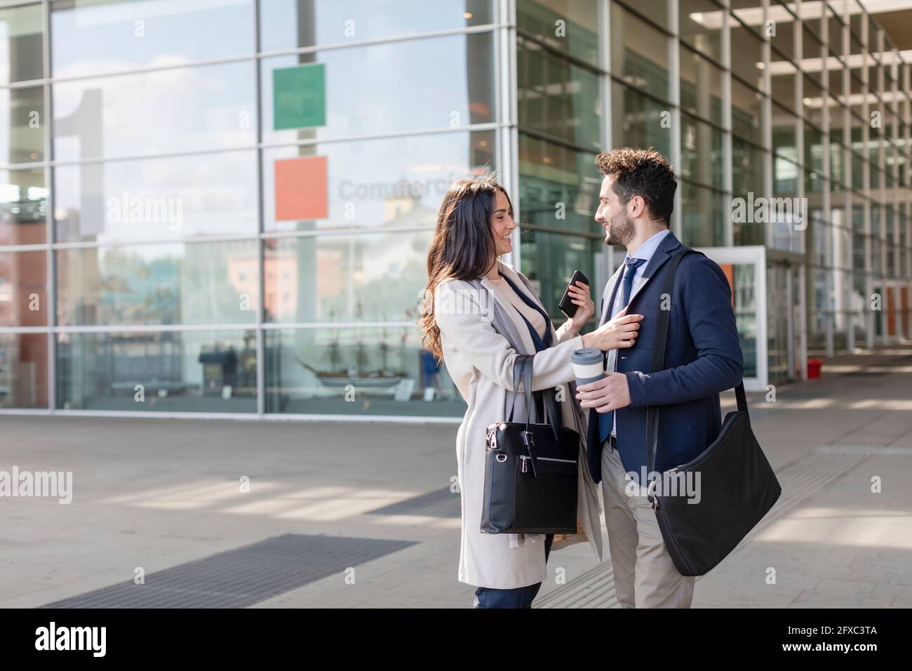 Colleagues talking while standing on footpath Stock Photo
