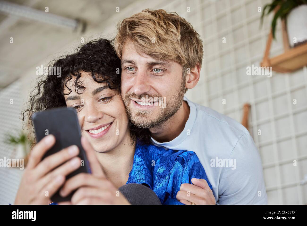 Young woman with boyfriend using mobile phone Stock Photo