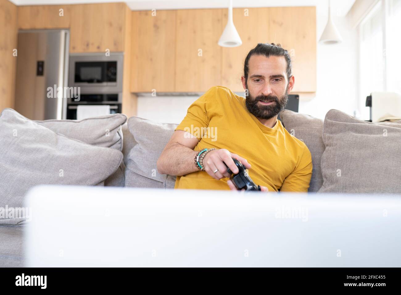 Man with joystick playing video game at home Stock Photo