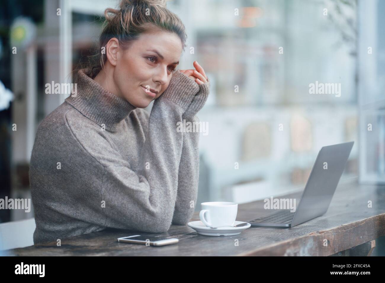 Mid adult business person contemplating while sitting by cafe window Stock Photo
