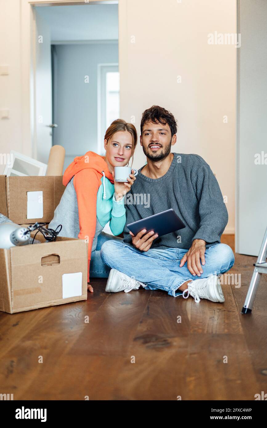 Young couple planning while sitting together at new home Stock Photo