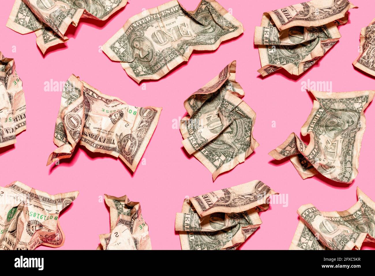 Pattern of crumpled one dollar bills lying against pink background Stock Photo