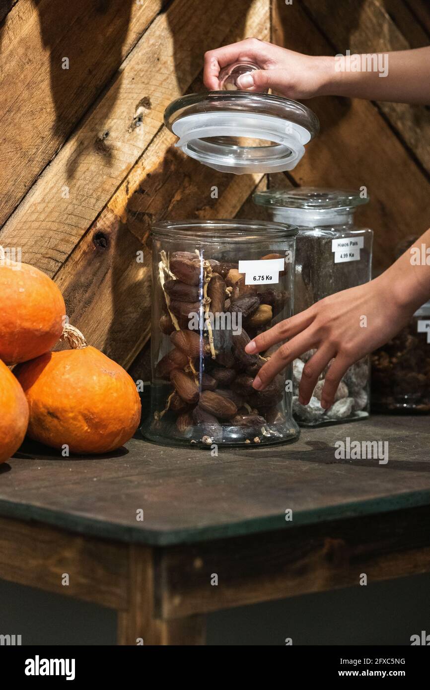 Woman opening dates jar at store Stock Photo