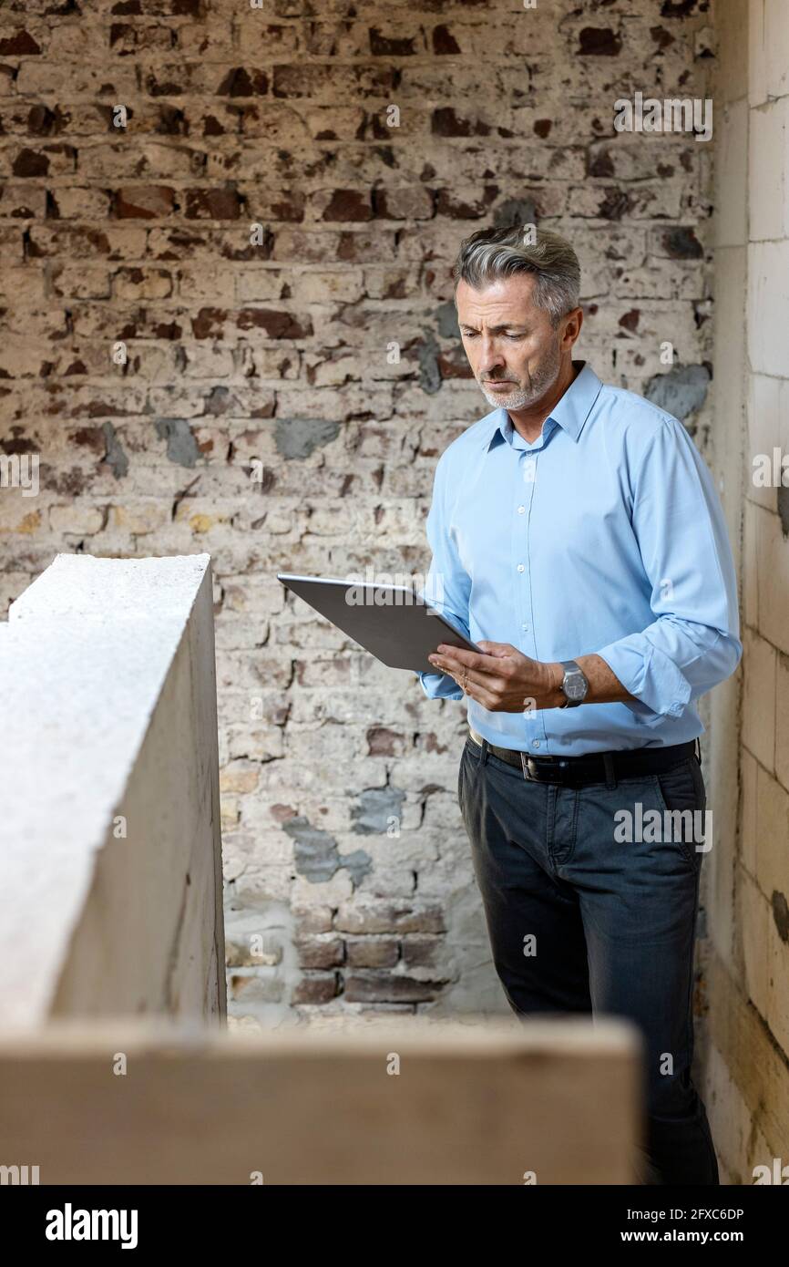 Male architect using digital tablet at construction site Stock Photo