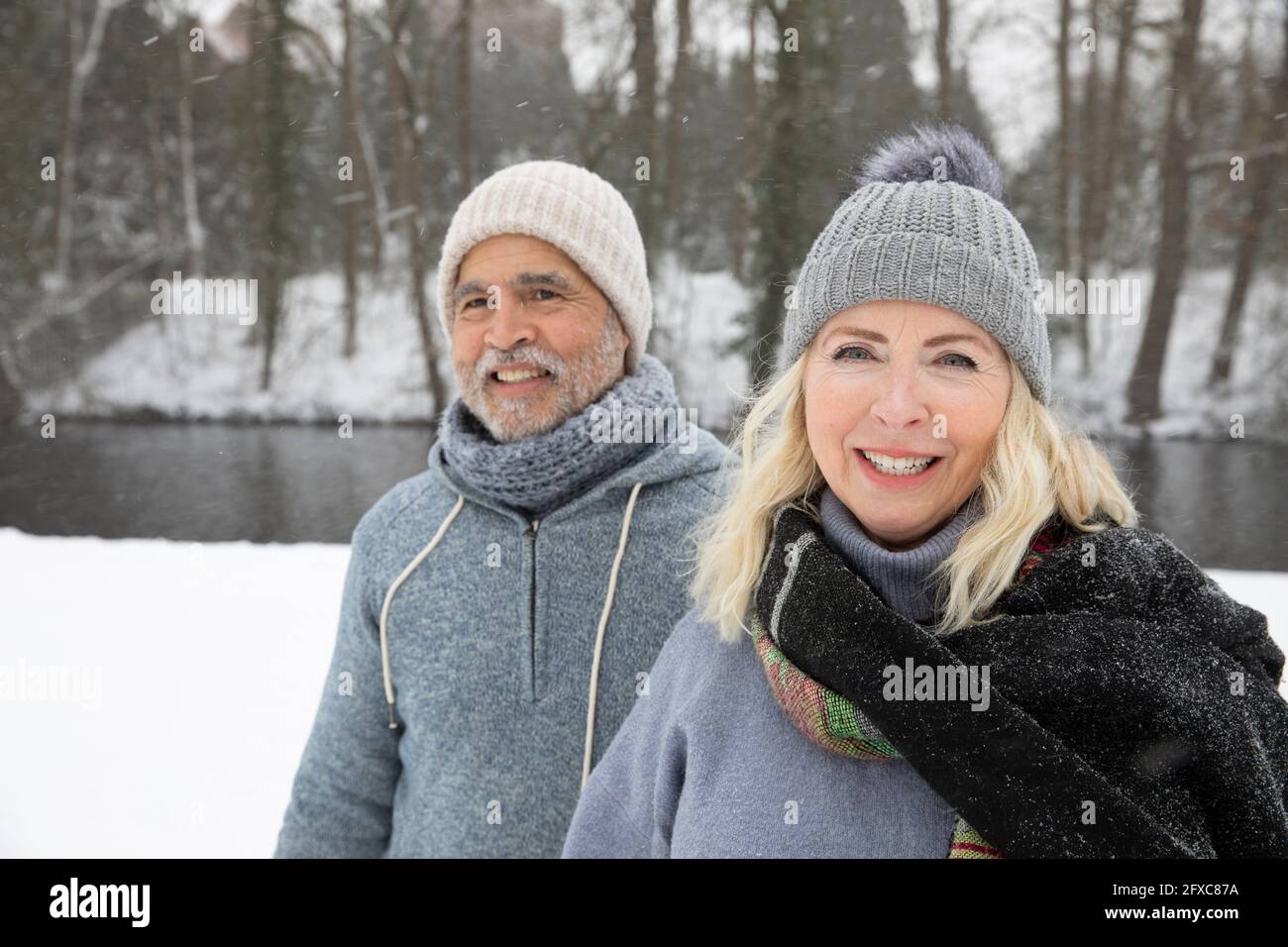 Smiling senior woman with man at park during winter Stock Photo