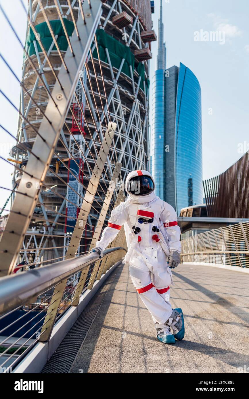 Male astronaut standing on one leg at bridge Stock Photo