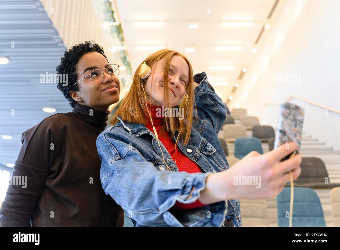 Multi-ethnic female friends making faces while taking selfie Stock Photo