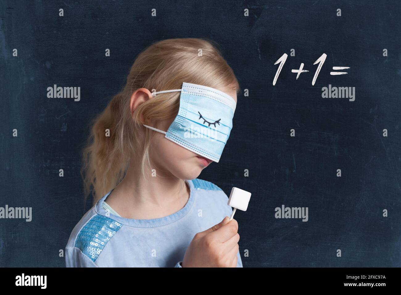 Girl holding lollipop while covering face with mask against black background with maths problem Stock Photo