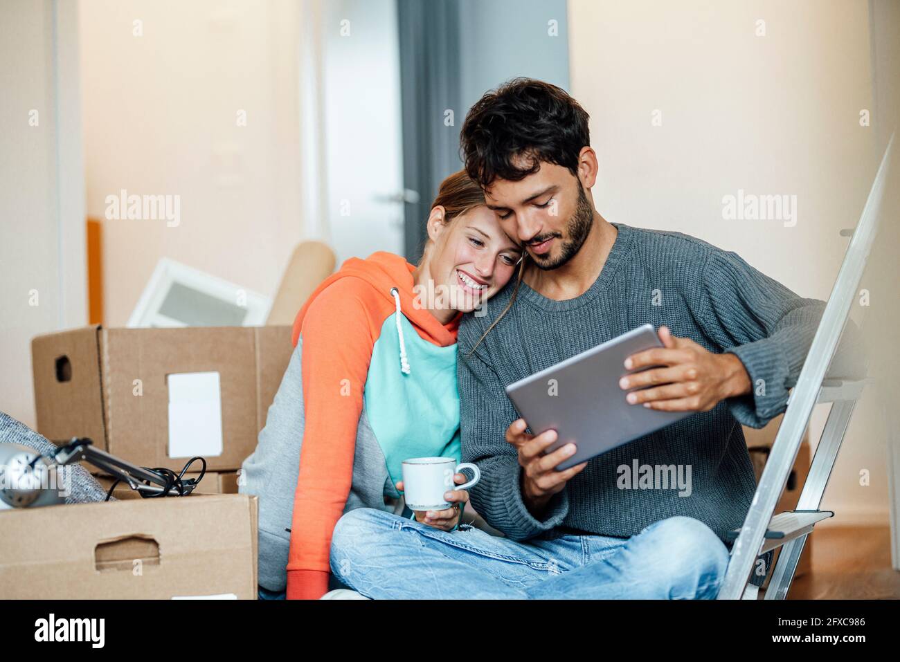 Young couple using digital tablet at new home Stock Photo