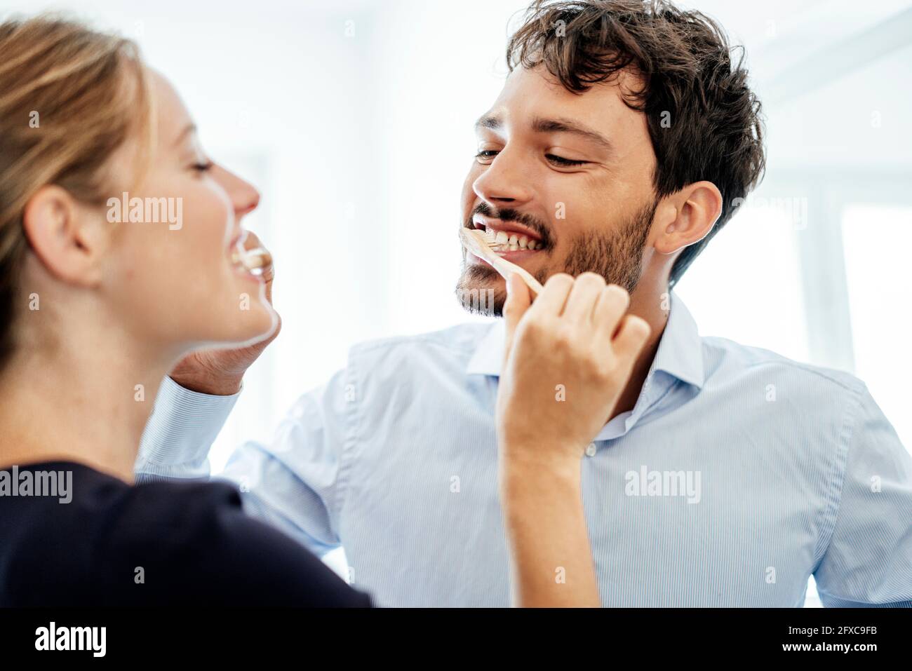Young couple brushing each other's teeth at home Stock Photo