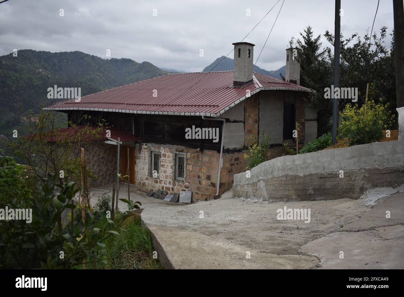 Shot of an old house with a reconstructed roof on top of it in the rural environment. Stock Photo