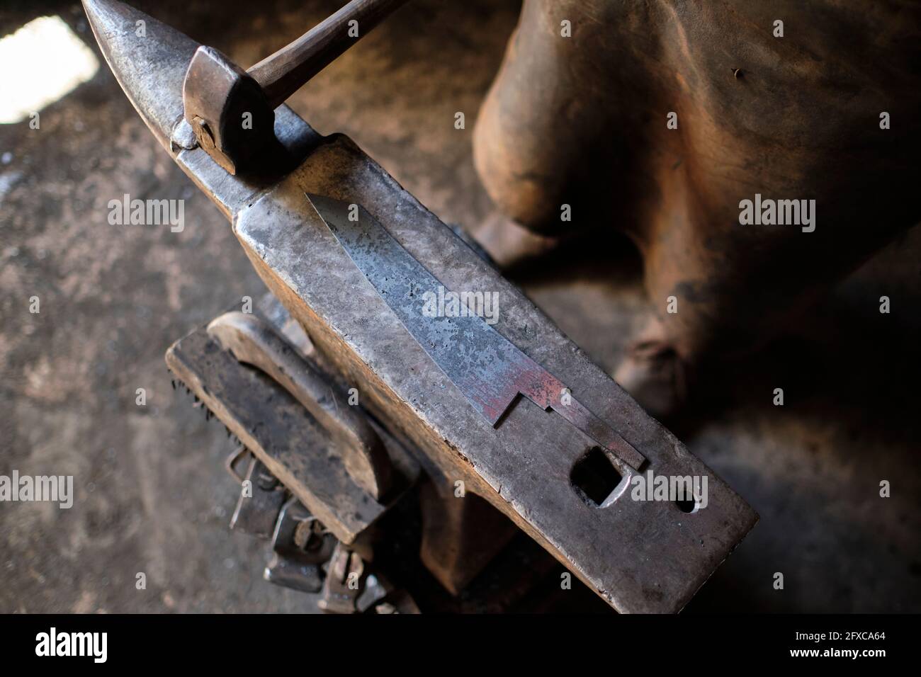 Male metal worker standing by anvil at workshop Stock Photo