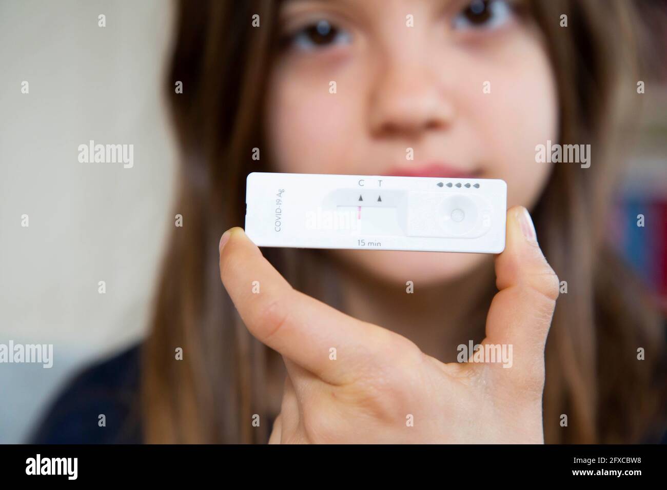 Girl holding rapid diagnostic test at home showing negative result Stock Photo