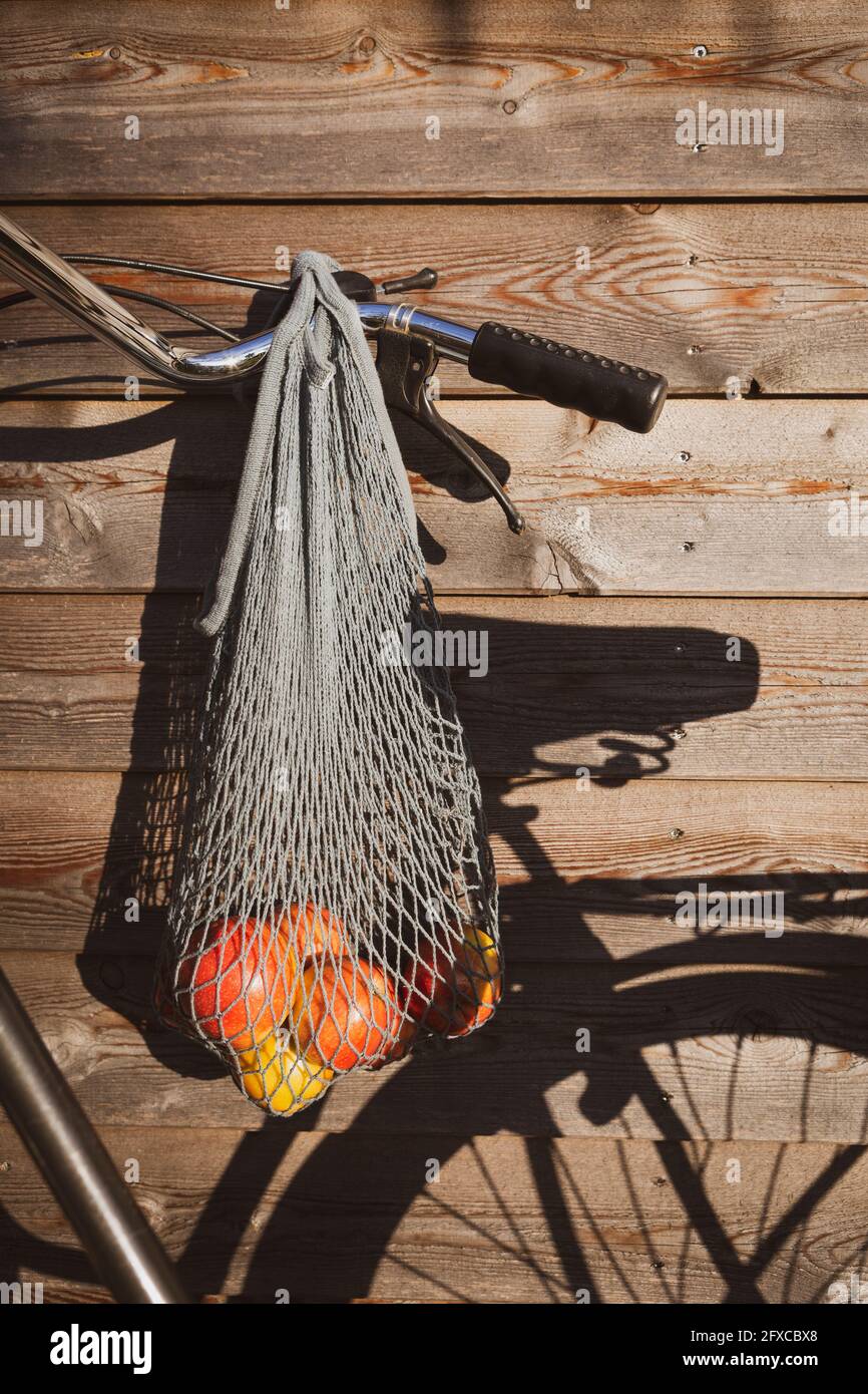 Apples in mesh bag hanging on bicycle Stock Photo