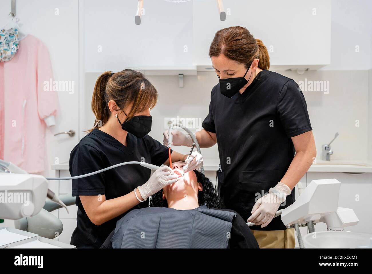 Female dentists doing dental suction of patient at clinic during pandemic Stock Photo Alamy