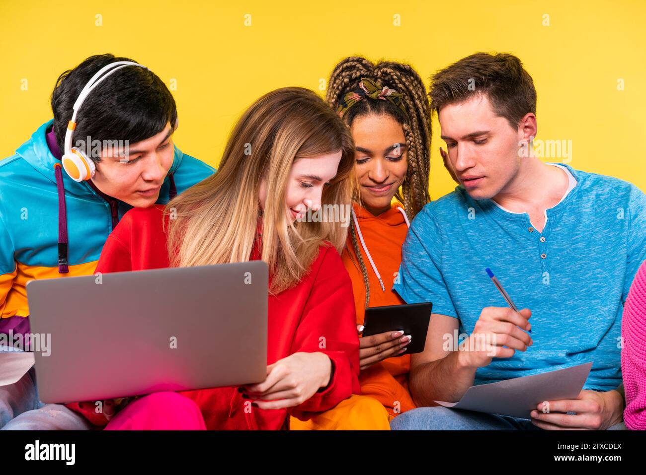 Young friends studying through digital tablet together Stock Photo
