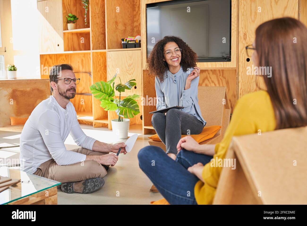 Entrepreneurs discussing while sitting in creative office Stock Photo