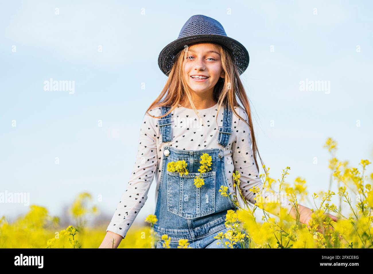 Cute girl wearing sun hat standing in agricultural field Stock Photo ...