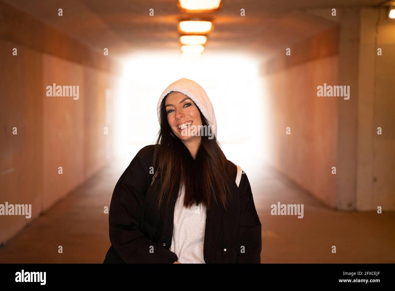 Beautiful woman wearing hooded jacket standing in underground Stock Photo Alamy