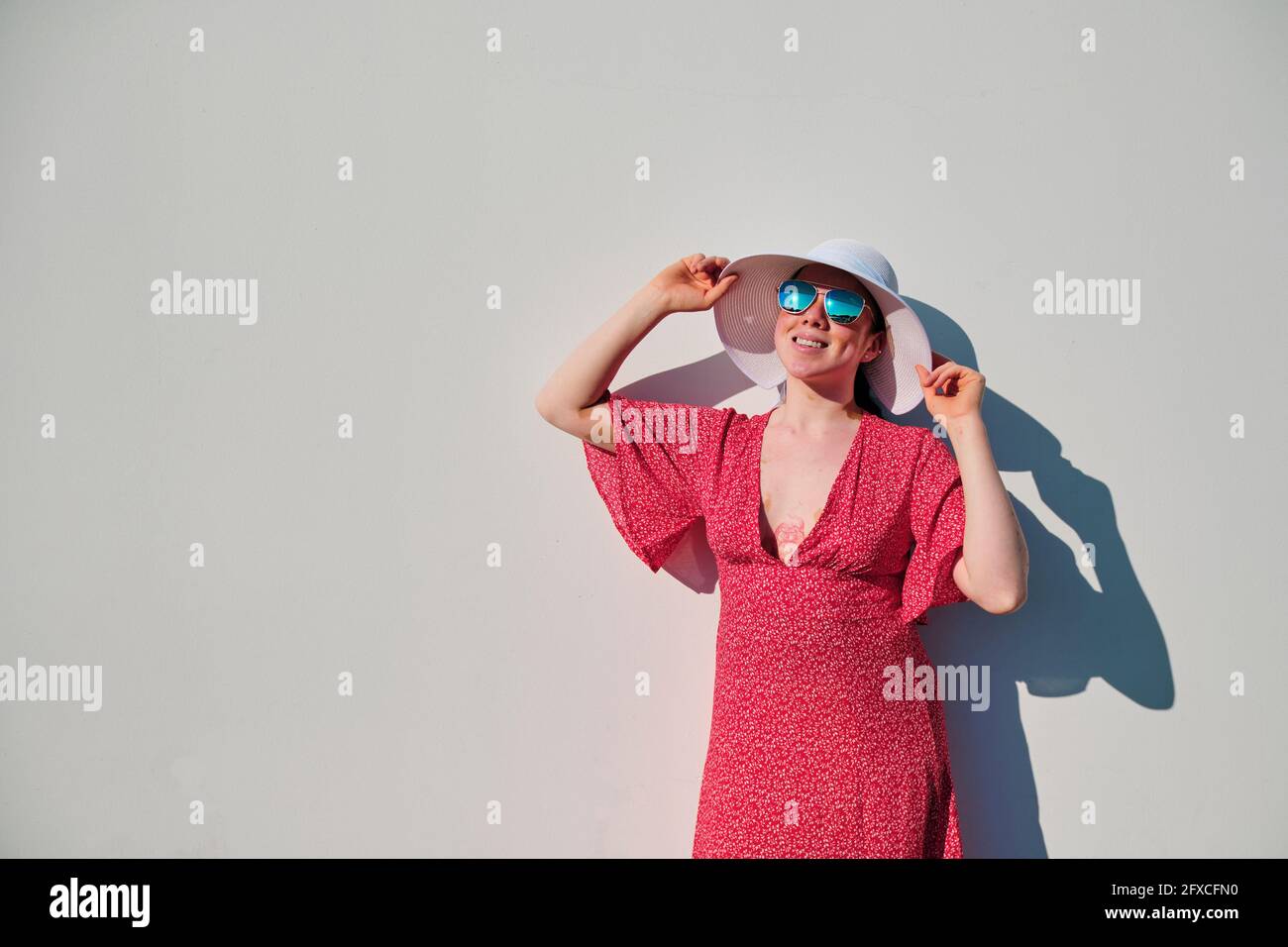 Woman holding sun hat hi-res stock photography and images - Alamy