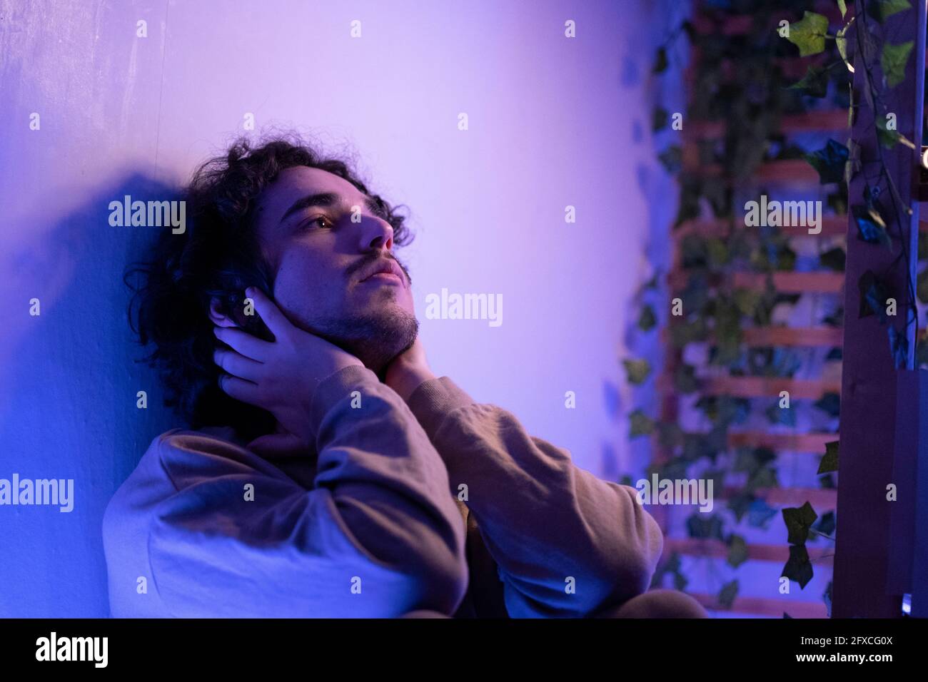 Man with headset holding game controller at home Stock Photo