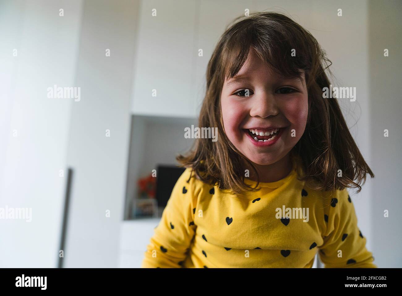Brown haired girl smiling at home Stock Photo
