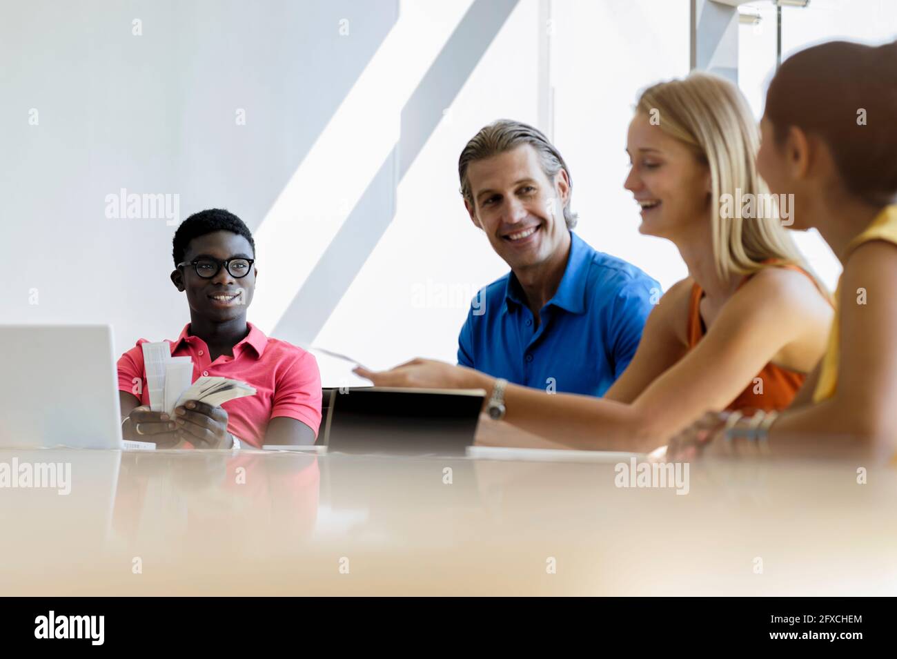 Male and female professionals smiling in business meeting at office Stock Photo